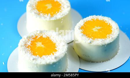 Petits gâteaux à l'orange et à la noix de coco sur fond bleu. Banque D'Images