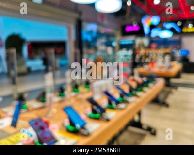 Présentez-vous avec des smartphones dans le magasin d'électronique moderne. Achetez un téléphone portable. De nombreux smartphones sont disponibles dans le magasin de technologie. Image floue comme Banque D'Images