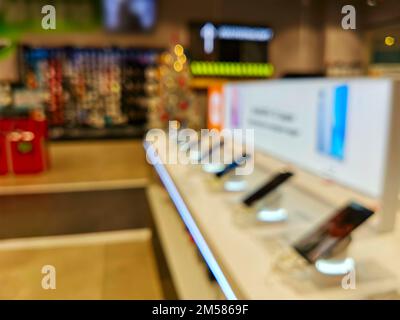 Présentez-vous avec des smartphones dans le magasin d'électronique moderne. Achetez un téléphone portable. De nombreux smartphones sont disponibles dans le magasin de technologie. Image floue comme Banque D'Images