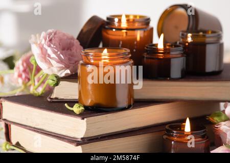 Un ensemble de bougies parfumées dans des pots en verre brun. Bougie parfumée faite à la main. Les bougies de soja brûlent dans un pot. Aromathérapie et détente au spa et à la maison. Faire feu dans un pot brun. Banque D'Images