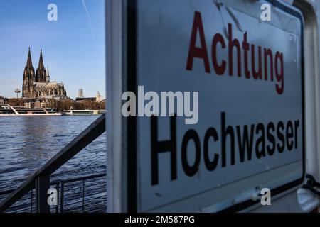 Cologne, Allemagne. 27th décembre 2022. Une barrière avec l'inscription 'Achtung Hochwasser' se dresse sur les rives du Rhin en face de la cathédrale. Une vague d'inondation a submergé des parties de la promenade du Rhin à Cologne. Les niveaux d'eau restent bien en dessous des valeurs auxquelles il y aurait un danger pour les zones habitées ou des restrictions sur le transport maritime.(à dpa/lnw: 'Petite vague d'inondation met la banque du Rhin sous l'eau') Credit: Oliver Berg/dpa/Alay Live News Banque D'Images