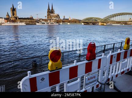 Cologne, Allemagne. 27th décembre 2022. Une barrière avec l'inscription 'Achtung Hochwasser' se dresse sur les rives du Rhin. Une vague d'inondation a submergé des parties de la promenade du Rhin à Cologne. Les niveaux d'eau restent bien en dessous des valeurs auxquelles il y aurait un danger pour les zones habitées ou des restrictions sur le transport maritime.(à dpa/lnw: 'Petite vague d'inondation met la banque du Rhin sous l'eau') Credit: Oliver Berg/dpa/Alay Live News Banque D'Images