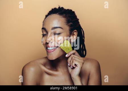 Belle femme qui fait des soins de beauté de peau et de visage. Prise de vue en studio axée sur les concepts cosmétiques et de soins de la peau Banque D'Images
