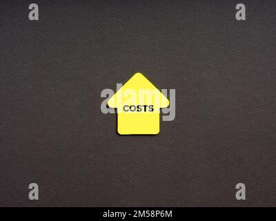 Augmentation des coûts élevés dans les concepts commerciaux et financiers. Le mot coût sur un papier de note en forme de flèche. Banque D'Images