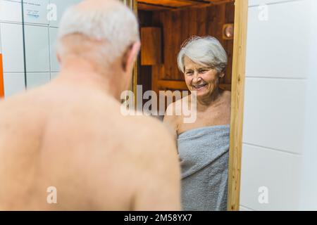 Un couple d'adultes plus âgés heureux s'est enveloppé dans des serviettes allant au sauna du spa. Photo de haute qualité Banque D'Images