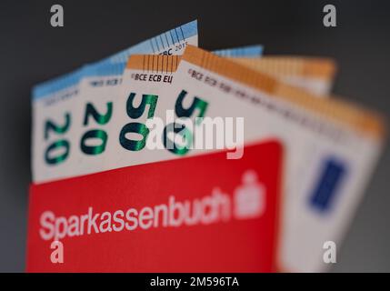 Cologne, Allemagne. 27th décembre 2022. Illustration - billets bloqués dans un livret de banque d'épargne. Les banques et les caisses d'épargne redécouvrent les épargnants, qui bénéficient de la hausse des taux d'intérêt après des années dans le marasme.(vers dpa: 'Les taux d'intérêt augmentent à nouveau après de longs marasme') Credit: Oliver Berg/dpa/Alay Live News Banque D'Images