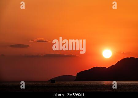 le soleil couchant sur les montagnes avec vue sur la mer. Banque D'Images