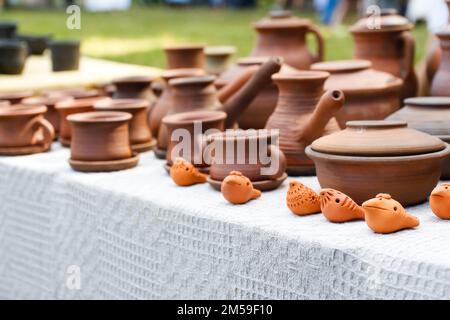 La poterie défie les cruches en faïence mugs dans la nature. Ensemble de pot et mug en céramique ancienne, cuisine rétro équipement de cuisine sur fond de festival. Ukraine Banque D'Images