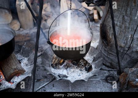 Cuisiner des soupes traditionnelles sur un feu ouvert dans un chou-fleur en vacances. Soupe à la viande et au Chili. Banque D'Images