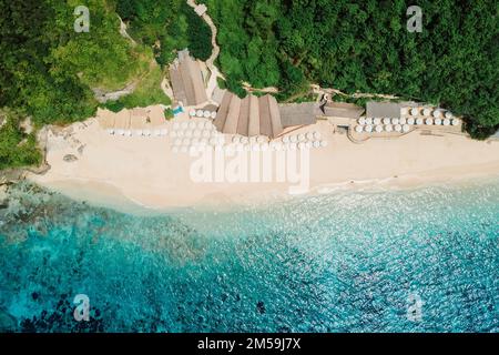 Vue aérienne sur l'océan bleu et la plage tropicale avec parasols à Bali Banque D'Images