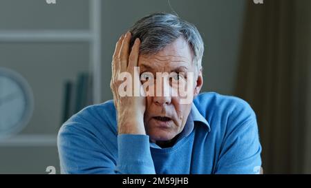 Choqué ancien homme de race blanche stupéfié âgé mature 60s homme se sentant inquiet choc peur prendre des lunettes de vue regardant la caméra stressée homme d'affaires Banque D'Images