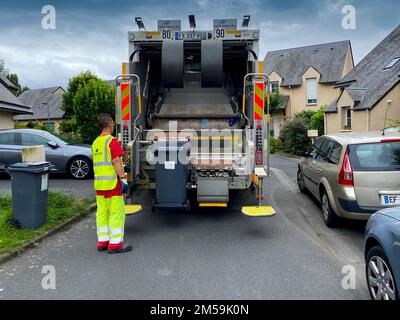 Caen, France 2022. Camion de ramassage des ordures, debout à côté d'un ouvrier de gilet jaune au travail dans un logement à une seule famille à Caen Banque D'Images