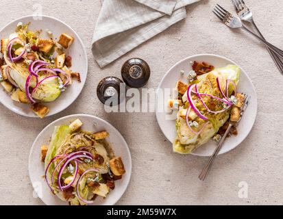 Assiettes de salade croquante et chaude nappées de bacon, de croûtons et d'oignons rouges. Banque D'Images