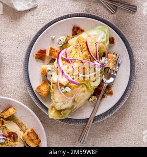 Une portion de salade chaude en coin, garnie de croûtons, d'oignons rouges et de bacon. Banque D'Images