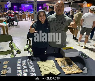 Tech. Le Sgt Carla Hudson et le Sgt. Maître Galen Ho se tiennent debout avec une variété de pièces de monnaie, de pièces de monnaie et de chemises portant les logos du Groupe des opérations expéditionnaires 380th lors d'une exposition de carrière à la base aérienne d'Al Dhafra, aux Émirats arabes Unis, le 13 février 2022. L'expo a permis au personnel affecté à la base d'acheter et d'échanger des correctifs d'unité et d'en apprendre davantage sur de nombreux domaines de carrière qui existent sur la base. Banque D'Images
