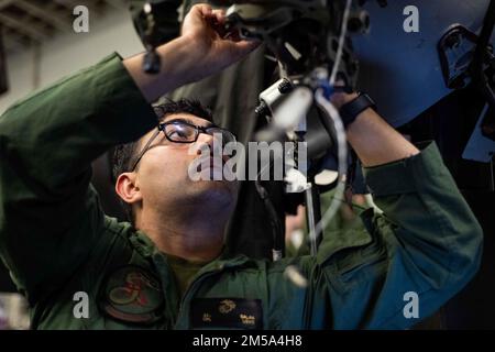 MER DES PHILIPPINES (14 février 2022) le caporal Jason Galan, de Pico Rivera, en Californie, affecté à l'unité expéditionnaire maritime (UMM) de 31st, effectue l'entretien d'un avion MV-22B Osprey tiltrotor du 31st UMM dans la baie hangar du navire d'assaut amphibie déployé par l'avant USS America (LHA 6). L'Amérique, navire chef de file de l'America Amphiobie Ready Group, ainsi que le MEU 31st, opère dans la zone de responsabilité de la flotte américaine 7th afin d'améliorer l'interopérabilité avec les alliés et les partenaires et de servir de force de réaction prête à l'emploi pour défendre la paix et la stabilité dans la région Indo-Pacifique. Banque D'Images