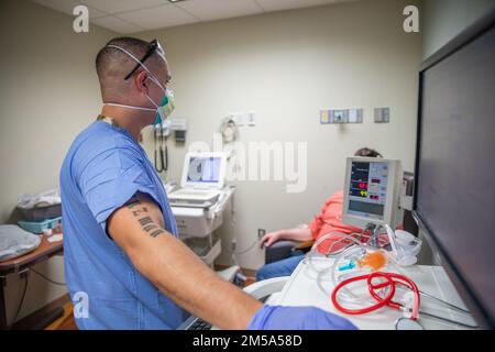 LANSING, Michigan - ÉTATS-UNIS Le Sgt Moises Guzman, un thérapeute respiratoire de l'équipe médicale militaire affecté au Tripler Army Medical Center à Honolulu, parle à un patient de l'hôpital Sparrow à Lansing, Michigan, le 15 février 2022. ÉTATS-UNIS Northern Command, par l'intermédiaire des États-Unis L'Armée du Nord demeure déterminée à fournir un soutien souple du ministère de la Défense à la réponse de l'ensemble du gouvernement à la COVID. Banque D'Images