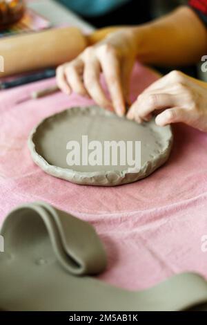 Atelier de poterie. Un plat d'artisanat en poterie à partir d'une argile crue. Création de céramiques pour adultes Banque D'Images