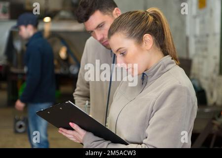 les employés de l'entrepôt vérifient les étiquettes sur les tablettes avec les marchandises Banque D'Images