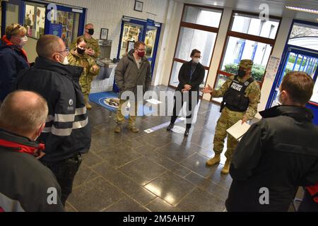 Le Maj. Denard Honeysuckle, arrière-plan droit, grand prévôt aux États-Unis Army Garrison Benelux - Bruxelles, informe le personnel américain et belge avant un verrouillage. Deux équipes, chacune composée de soldats de la police militaire, de forces de l'ordre locales de la nation hôte, de chiens de travail et d'évaluateurs, ont peigné les couloirs de l'école américaine de Bruxelles lors d'un exercice d'intervention d'urgence le 16 février 2022 à l'annexe Sterrebeek de Zaventem, en Belgique. Banque D'Images