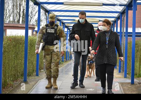 De gauche à droite, le Maj. Denard Honeysuckle, le grand prévôt aux États-Unis Army Garrison Benelux - Bruxelles; Tom Nollens, inspecteur au service de police de Zaventem; et Collette Tate, directrice de l'école américaine de Bruxelles, marchent entre les bâtiments du campus bas. Deux équipes, chacune composée de soldats de la police militaire, de forces de l'ordre locales de la nation hôte, de chiens de travail et d'évaluateurs, ont peigné les couloirs de l'école américaine de Bruxelles lors d'un exercice d'intervention d'urgence le 16 février 2022 à l'annexe Sterrebeek de Zaventem, en Belgique. Banque D'Images