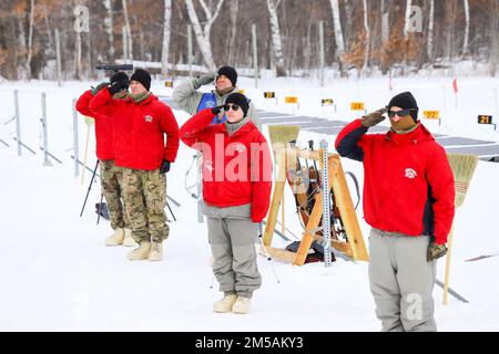 Le personnel de soutien de la Garde nationale du Minnesota salue pendant la partie de l'hymne national des États-Unis au début de la course de relais des Championnats de biathlon du Bureau de la Garde nationale 2022, Camp Ripely, MN, 16 février 2022. Le championnat de biathlon NGB est un événement d'une semaine comprenant une course de sprint, une course de poursuite, une course de relais et une course de patrouille. Banque D'Images