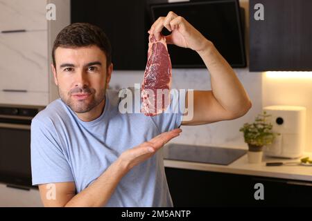 Amateur de viande montrant un délicieux steak cru Banque D'Images