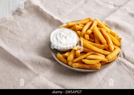 Frites maison avec vinaigrette Ranch sur une assiette, vue latérale. Banque D'Images