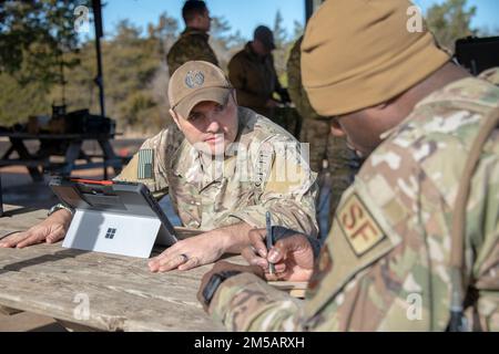 ÉTATS-UNIS Tech. De la Force aérienne Le Sgt Justin Davis, 137th combat Training Flight, responsable du cours de qualification du contrôleur d'attaque du terminal conjoint, Oklahoma Air National Guard, donne à un élève de l'équipe de soutien de la mission (MST) sa première coordonnée sur une grille pour trouver sur une carte lors d'un exercice sur le terrain à Oklahoma City, le 10 février 2022. Les instructeurs ont laissé des marqueurs à des endroits dans la région où les élèves du MST ont utilisé leur formation de navigation terrestre pour localiser. Banque D'Images