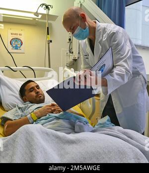 Le major de l'armée Michael Morrison, chirurgien traumatologue de chirurgie générale, unité de soins intensifs, Centre médical régional de Landstuhl, discute d'un plan de suivi avec un patient en soins intensifs au LGRC, février 18. Le Landstuhl Regional Medical Center, le plus grand centre de traumatologie américain outre-mer, a récemment été accueilli dans la Société allemande de chirurgie traumatologique, ou Deutsche Gesellschaft für Unfallchirurgie – DGU, devenant le premier centre de traumatologie américain en coalition avec un réseau étranger de traumatologie. L'adhésion exclusive partenaire LLRMC avec les centres allemands de traumatologie pour améliorer l'interopérabilité et la coordination des patients Banque D'Images