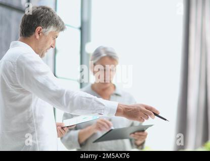 homme d'affaires montrant quelque chose à une femme d'affaires mûre vu en personne Banque D'Images
