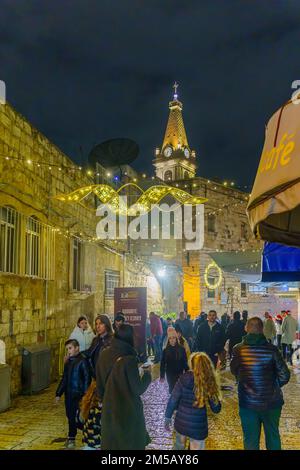 Jérusalem, Israël - 24 décembre 2022 : scène de la veille de Noël dans les ruelles du quartier chrétien de la vieille ville, avec des visiteurs. Jérusalem, Israël Banque D'Images