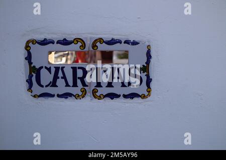 Gros plan d'une boîte aux lettres faite de carreaux décorés de tons bleu et jaune et avec le mot 'cartas' écrit en espagnol Banque D'Images