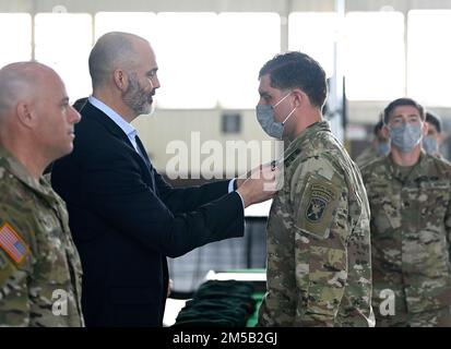 Un soldat affecté aux États-Unis L'École et le Centre de guerre spéciale John F. Kennedy reçoit un béret vert du sergent de commandement à la retraite, le major Patrick McCauley, lors d'une première formation régimentaire à fort Bragg, en Caroline du Nord, en 17 février 2022. La cérémonie a marqué l'achèvement du cours de qualification des forces spéciales où les soldats ont gagné l'honneur de porter le béret vert, le harnais officiel des forces spéciales. Banque D'Images