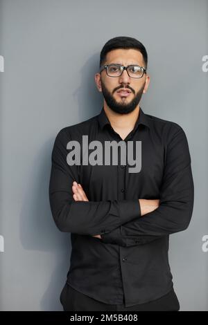 Jeune homme d'affaires élégant vêtu d'une chemise en Jean décontractée avec montre intelligente au poignet Banque D'Images