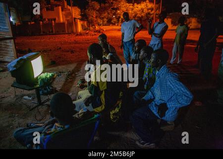 Enfants regardant la télévision ensemble dans la rue , Bamako , Mali , Afrique de l'Ouest . Banque D'Images