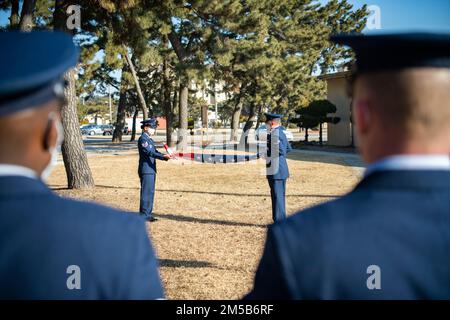Le sergent d'état-major Phu San et la première classe d'Airman Anthony Paree, 8th Fighter Wing base Honor Guardsmen, déploient un drapeau américain en vue de la retraite à la base aérienne de Kunsan, République de Corée, le 18 février 2022. Lorsqu'un drapeau américain est considéré comme inutilisable, il doit être honoré d'une cérémonie de retraite et brûlé. Banque D'Images
