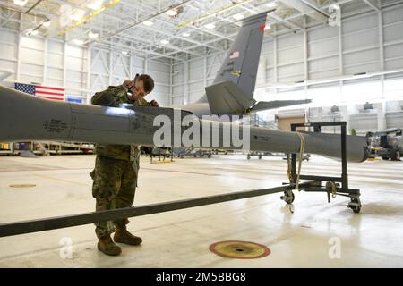 Le chef d'équipage du 22nd Escadron de maintenance, Jacob Coleman, inspecte le boom d'un KC-135 Stratotanker lors d'une inspection isochrone, le 18 février 2022, à la base aérienne McConnell, Kansas. Les aviateurs inspectent la rampe pour détecter et diagnostiquer tout problème qui pourrait empêcher la rampe de s'étendre ou de se rétracter pendant le vol. Banque D'Images