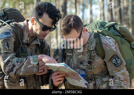 Les cadets Victor Dasilva et Evan Moller, de l'Université de Caroline de l'est, discutent des points de tracé sur leur carte alors qu'ils préparent leur prochain mouvement lors de l'événement de navigation terrestre au défi des Rangers du ROTC de l'Armée de brigade de 4th sur 19 février 2022 à fort A.P. Hill, Virginie Les équipes de cadets ont navigué jusqu'à un point assigné en utilisant uniquement une carte, un rapporteur et une boussole. Une fois qu'ils ont atteint le point qui leur a été attribué, les membres de l'équipe s'efforcer d'identifier trois grenades à main différentes avant de poursuivre le cours sur les obstacles. | photo de Sarah Windmueller, États-Unis Affaires publiques du commandement des cadets de l'Armée Banque D'Images