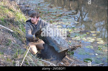 Daniel Learn, 502nd escadron du génie civil, récupère un baril du ruisseau Salado pendant la Basura Bash, le 19 février, à la base commune de San Antonio-fort Sam Houston. Basura Bash est le plus grand ramassage de litière dans un bassin versant d'une journée au Texas. Banque D'Images