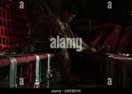 Le sergent d'état-major Andy Massa, chef d'équipage de l'escadron de transport aérien expéditionnaire du 36th, resserre les lacets de sa chaussure tout en se mettant en route pour effectuer une mission de chute d'air avec l'armée de l'air du Bangladesh (BAF) pendant l'exercice COPE Sud 2022, le 20 février 2022, au-dessus du Bangladesh. Les aviateurs affectés à l’EAS de 36th ont travaillé côte à côte avec les pilotes et les agents d’entretien de la BAF pour effectuer des chutes d’air et des vols de bas niveau dans le cadre des tâches de la journée. L'exercice COPE Sud offre aux forces aériennes du Pacifique et aux forces armées du Bangladesh l'occasion de renforcer leurs relations et d'améliorer l'interopérabilité, d'opérer plus efficacement Banque D'Images