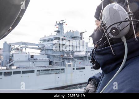 OCÉAN ATLANTIQUE (22 février 2022) – Spécialiste culinaire, le Matelot de mer Hannah Wood est à l'affût de tribord sur l'aile du pont du destroyer à missiles guidés USS Donald Cook (DDG 75) lors d'un réapprovisionnement en mer (RAS) avec le navire auxiliaire allemand FGS Berlin (A1411) lors de l'exercice de l'OTAN Dynamic Guard 22-1, février 22. Donald Cook est déployé sur le théâtre d'opérations européen et participe à une série d'activités maritimes à l'appui de la flotte américaine 6th et des alliés de l'OTAN. Banque D'Images