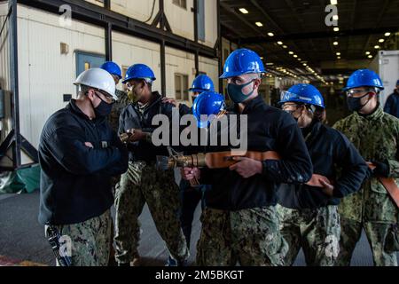 220223-N-SI601-1121 YOKOSUKA, Japon (23 février 2022) les marins simulent la lutte contre un incendie de baie hangar lors d'un exercice de contrôle des dommages à bord des États-Unis Le seul porte-avions de la Marine, le USS Ronald Reagan (CVN 76). Ronald Reagan, le navire amiral du Carrier Strike Group 5, fournit une force prête à combattre qui protège et défend les États-Unis, et soutient les alliances, les partenariats et les intérêts maritimes collectifs dans la région Indo-Pacifique. Banque D'Images