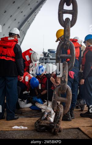 220223-N-HA192-1127 NORFOLK, VIRGINIE. (23 février 2022) - les marins affectés au navire d'assaut amphibie USS Bataan (LHD 5) effectuent l'entretien de la préservation de la chaîne d'ancrage côté port le 23 2022 février. Bataan est à la base navale de Norfolk. Banque D'Images