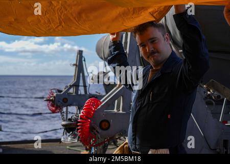 OCÉAN PACIFIQUE (23 février 2022) technicien en cryptographie (technique) le Matelot Zachary Cook, originaire de Kansas City, dans le Mississippi, maintient une bâche pare-fumée pendant une évolution de la formation sur le contrôle des dommages à bord du navire d'atterrissage amphibie USS Pearl Harbor (LSD 52) de la classe Harpers Ferry, dans l'océan Pacifique, le 23 février 2022. Les marins et les marins du Essex Amphiobie Ready Group (ARG) et de l'unité expéditionnaire maritime 11th (MEU) mènent actuellement des opérations de routine dans la flotte américaine 3rd. Banque D'Images