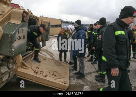 Les cadets polonais des pompiers quittent un véhicule de combat Bradley à Drawsko Pomorskie, Pologne, le 23 février 2022. Au cours de la tournée, les recrues ont exploré divers véhicules appartenant au bataillon 2nd, au 34th Armored Regiment, à l'équipe de combat de la Brigade blindée 1st, à la 1st Infantry Division. Banque D'Images