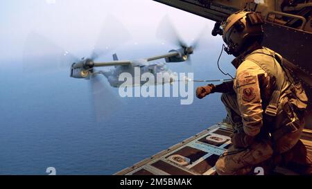 Un maître de charge d'aéronef de transport de combat multimission MC-130J Commando II avec l'escadron des opérations spéciales 1st, 353rd escadre des opérations spéciales, signale un CV-22B Osprey affecté à l'escadron des opérations spéciales 21st, 353rd escadre des opérations spéciales, Tout en effectuant le ravitaillement air-air à rotor incliné au large de la côte de U-Tapao dans le Royaume de Thaïlande pendant Cobra Gold 2022, 23 février 2022. Le CG 22 est la version 41st de l'exercice international de formation qui soutient l'état de préparation et met l'accent sur la coordination de l'action civique, de l'aide humanitaire et des secours en cas de catastrophe. Du 22 février au mois de mars Banque D'Images