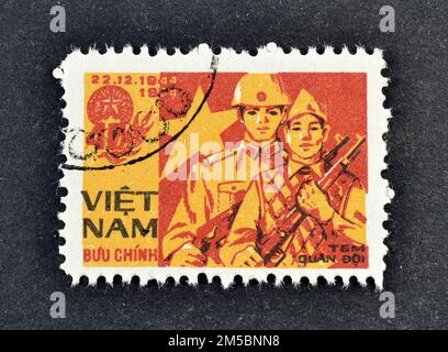 Timbre-poste annulé imprimé par le Vietnam, qui montre des hommes de l'armée vietnamienne, franc militaire vers 1984. Banque D'Images