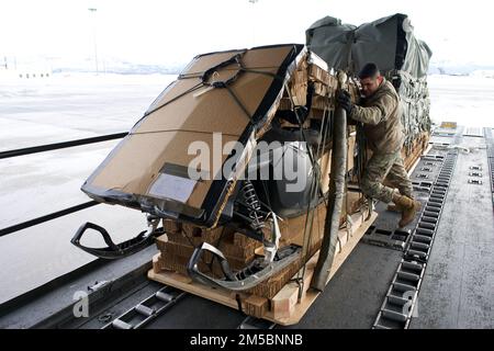 BASE CONJOINTE ELMENDORF-RICHARDSON, Alaska -- le Sgt. Santiago Maya, Sgt. Maître de la Garde nationale aérienne de l'Alaska, 176th Escadron de préparation à la logistique le surintendant des opérations de transport aérien, charge une machine à neige dans un escadron de transport aérien 144th C-17 Globemaster III le 23 février 2022, à la base conjointe Elmendorf-Richardson. La machine à neige fait partie de l'équipement utilisé sur la glace de mer du pôle Nord à l'appui des États-Unis Personnel de la Marine dans le cadre de l'exercice sur les glaces 2022. ICEX 2022 est un exercice de trois semaines conçu pour effectuer des recherches, tester et évaluer les capacités opérationnelles dans la région arctique. Banque D'Images