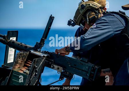 MER DES PHILIPPINES (24 février 2022) Christopher Lamotte, le compagnon du chef Gunner, de Los Angeles, élimine une embâcle dans une mitrailleuse de calibre M2A1 .50 lors d’un exercice de tir en direct à bord du destroyer de missile guidé de classe Arleigh Burke USS Spruance (DDG 111). Abraham Lincoln Strike Group est en cours de déploiement prévu dans la zone d'exploitation de la flotte américaine 7th afin d'améliorer l'interopérabilité par le biais d'alliances et de partenariats tout en servant de force de réaction prête à l'emploi pour soutenir une région libre et ouverte d'Indo-Pacifique. Banque D'Images